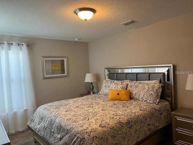 carpeted bedroom featuring a textured ceiling