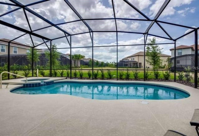 view of swimming pool with a patio area and glass enclosure