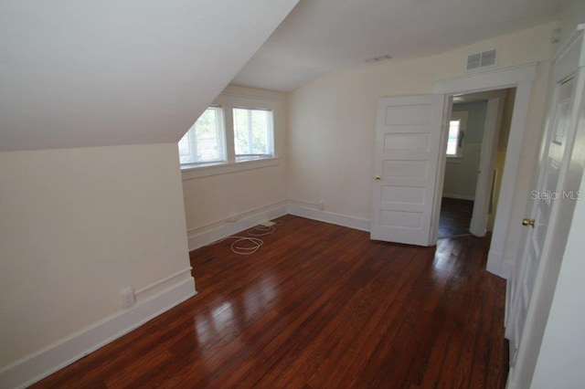 bonus room with dark hardwood / wood-style flooring and vaulted ceiling