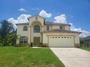 mediterranean / spanish house featuring a garage and a front yard