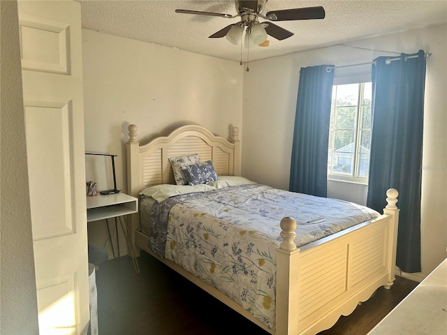 bedroom with a textured ceiling, ceiling fan, and dark hardwood / wood-style floors