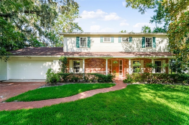 view of front of house with covered porch, a garage, and a front lawn