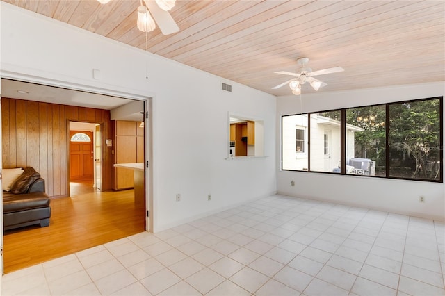 tiled spare room with ceiling fan, wooden walls, and wood ceiling