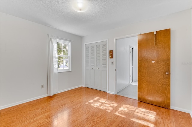 unfurnished bedroom featuring light hardwood / wood-style floors and a textured ceiling