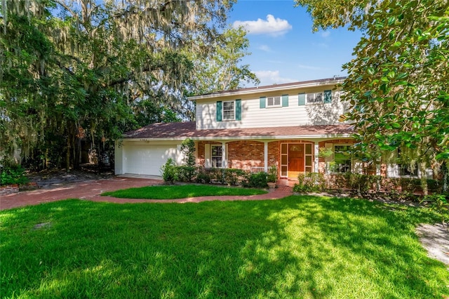 view of front of home with covered porch, a front yard, and a garage