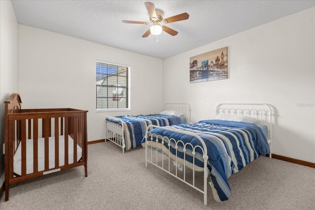 carpeted bedroom with a textured ceiling and ceiling fan