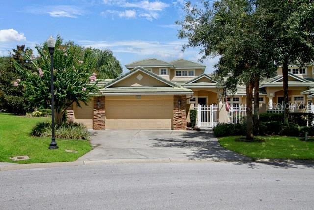 view of front of home with stone siding, a front lawn, concrete driveway, and a garage