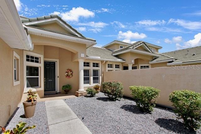 property entrance with fence and stucco siding