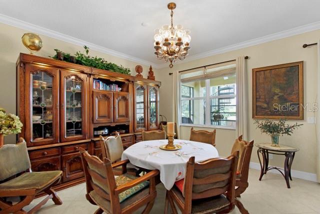 dining area with an inviting chandelier and ornamental molding