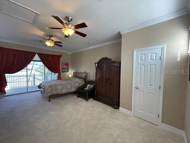 carpeted bedroom with ceiling fan, access to exterior, and crown molding