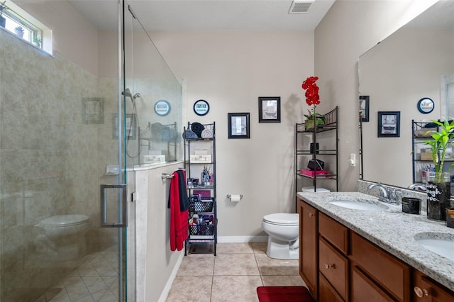 bathroom featuring tile patterned flooring, vanity, a shower with shower door, and toilet