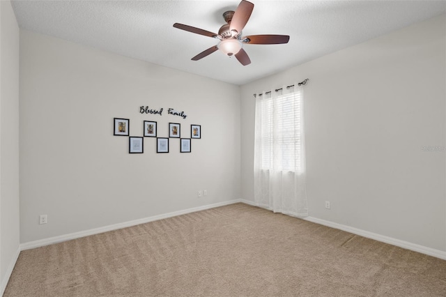 carpeted empty room with ceiling fan and a textured ceiling