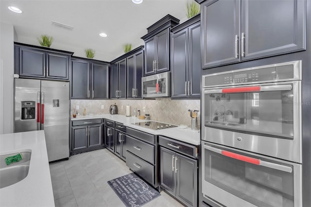 kitchen featuring tasteful backsplash, sink, stainless steel appliances, and light tile patterned flooring