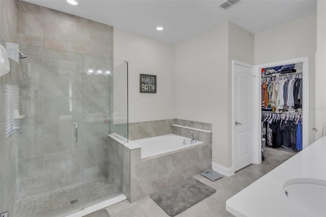 bathroom featuring sink, tile patterned floors, and plus walk in shower