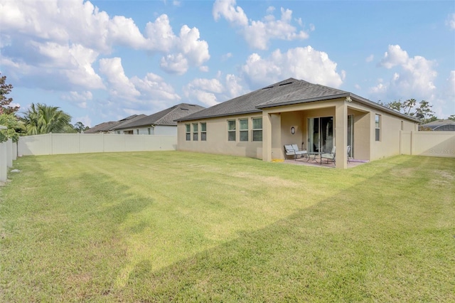 back of house featuring a patio area and a yard