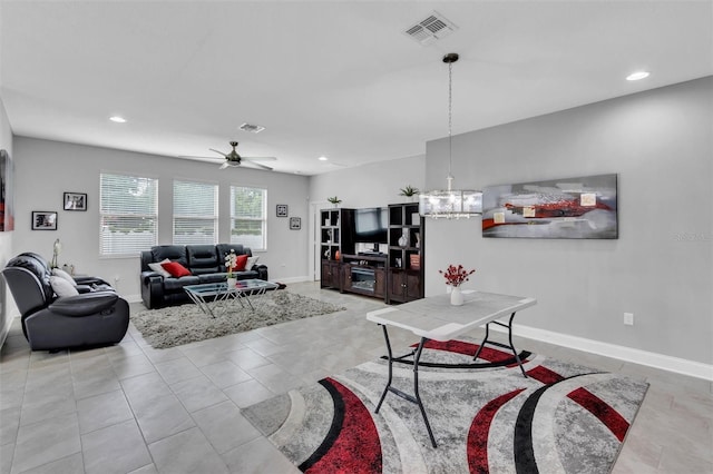 tiled living room featuring ceiling fan with notable chandelier