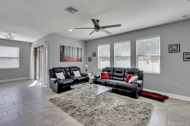 living room featuring a textured ceiling and ceiling fan