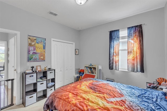 carpeted bedroom with multiple windows and a closet