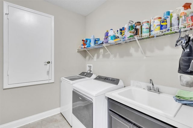 laundry room featuring light tile patterned floors, sink, and washer and dryer