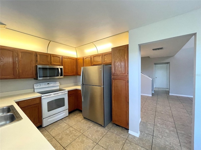 kitchen with sink, light tile patterned floors, and stainless steel appliances