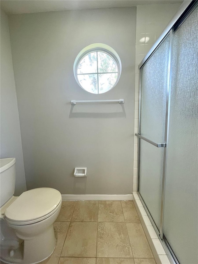 bathroom with toilet, tile patterned flooring, and a shower with door