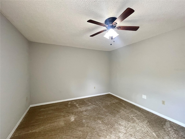 empty room featuring ceiling fan, dark carpet, and a textured ceiling