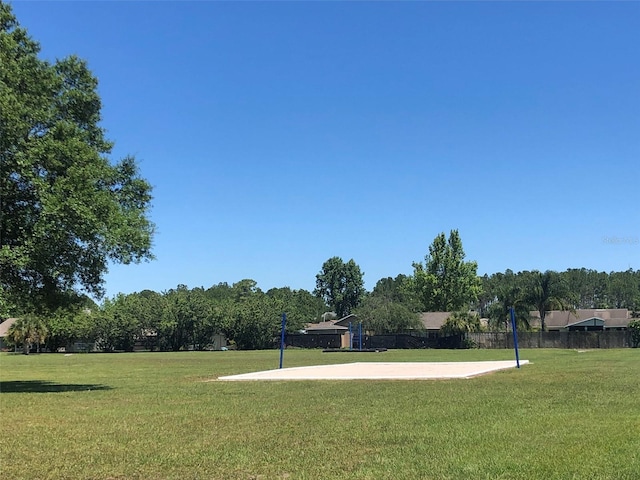 surrounding community with volleyball court and a yard