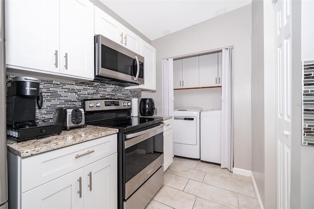 kitchen featuring light tile patterned floors, backsplash, white cabinetry, washer and dryer, and appliances with stainless steel finishes