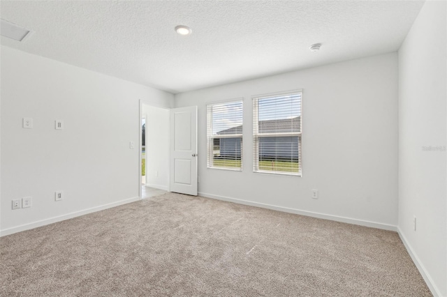 unfurnished room with carpet, a textured ceiling, and baseboards