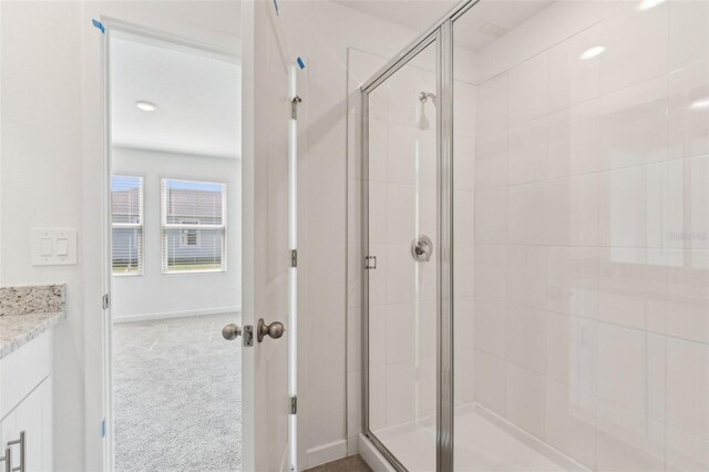 full bathroom featuring a stall shower, vanity, and baseboards