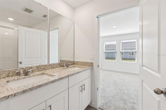 full bathroom with double vanity, baseboards, visible vents, and a sink