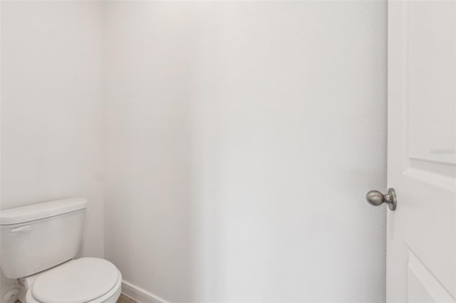 bathroom featuring toilet and baseboards