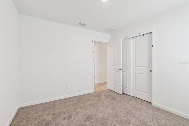 unfurnished bedroom with light colored carpet, visible vents, and baseboards