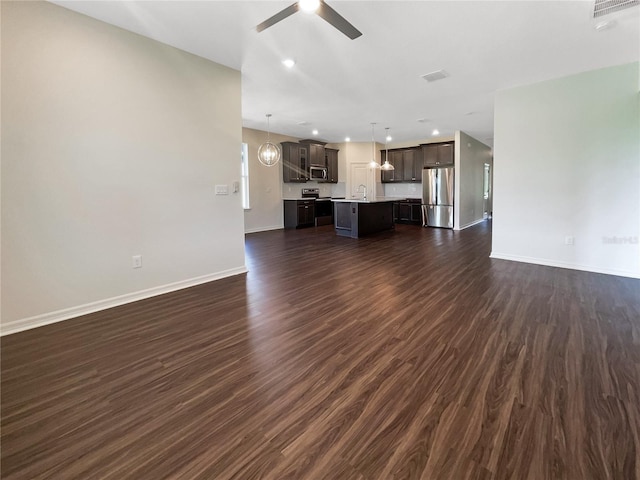 unfurnished living room featuring dark hardwood / wood-style floors, ceiling fan, and sink