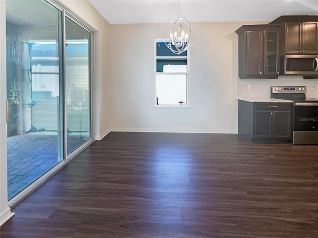 interior space featuring a notable chandelier, plenty of natural light, and dark wood-type flooring