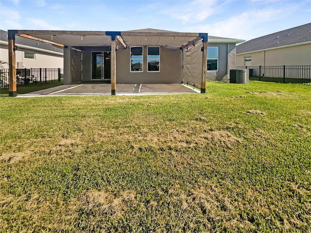 rear view of house with central air condition unit, a patio area, and a yard