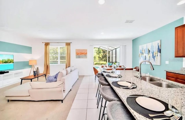 kitchen with sink, a breakfast bar area, and light tile patterned floors