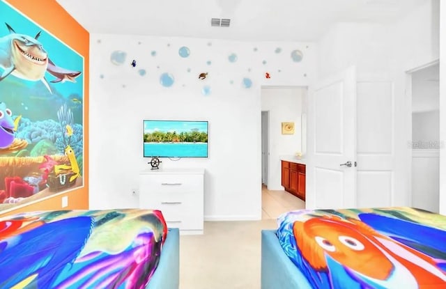 bedroom featuring ensuite bathroom and light tile patterned floors