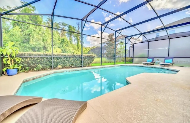 view of swimming pool featuring a patio and glass enclosure