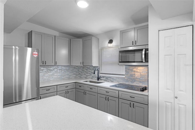 kitchen featuring sink, appliances with stainless steel finishes, decorative backsplash, and gray cabinets