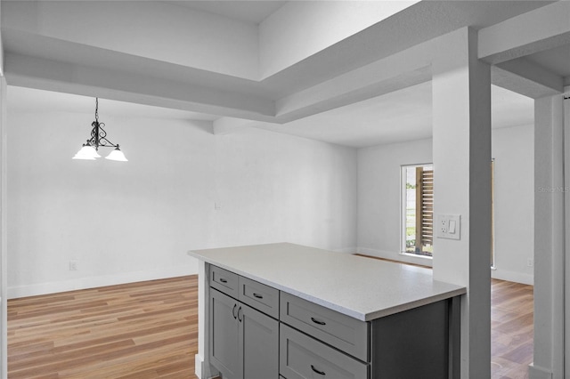 kitchen with decorative light fixtures, gray cabinets, and light hardwood / wood-style flooring