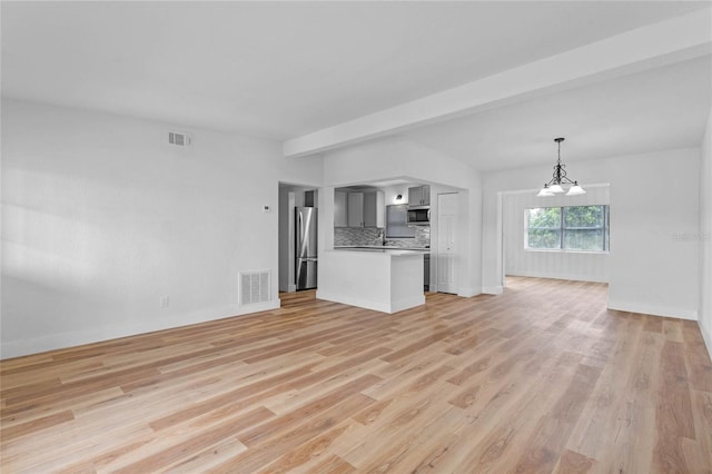 unfurnished living room with light hardwood / wood-style floors, beam ceiling, and a notable chandelier