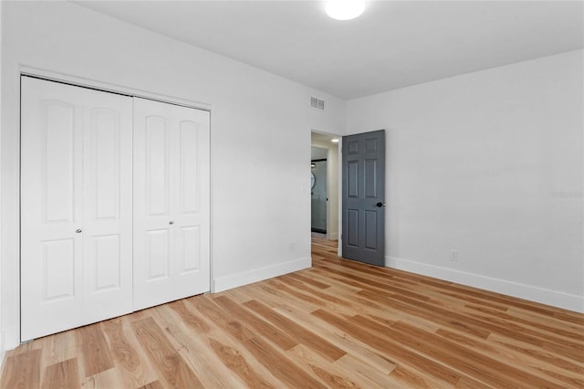 unfurnished bedroom featuring a closet and light hardwood / wood-style flooring