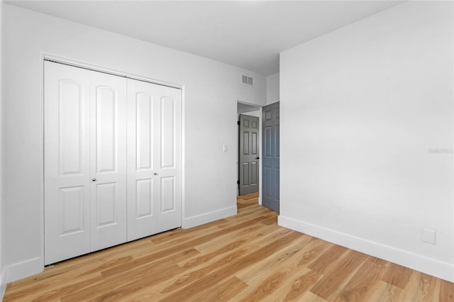 unfurnished bedroom with a closet and light hardwood / wood-style floors