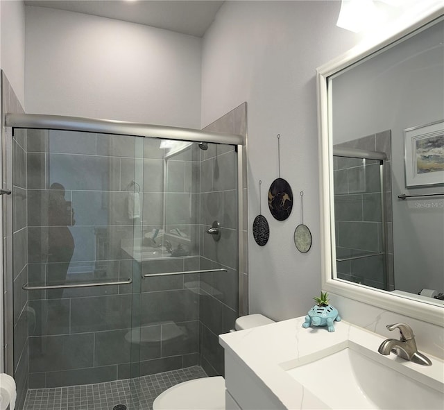 bathroom with walk in shower, vanity, and toilet