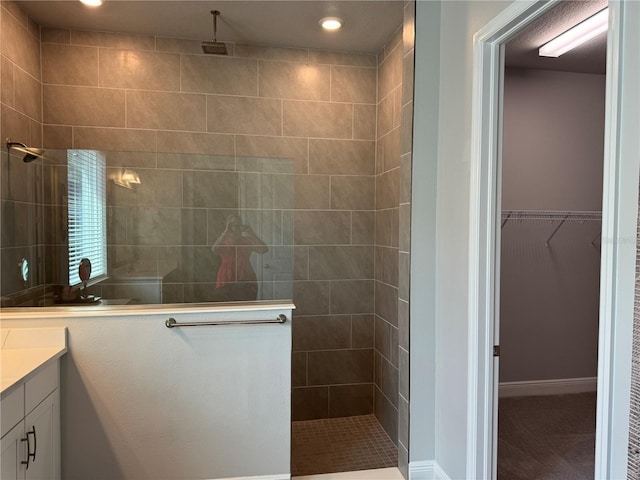 bathroom with vanity and a tile shower