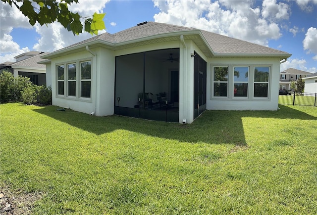 rear view of house featuring a yard and a sunroom