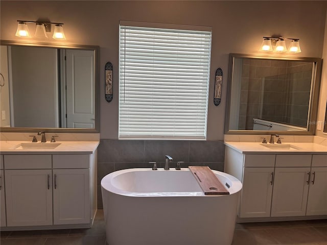 bathroom with tile patterned flooring, a bath, vanity, and tile walls