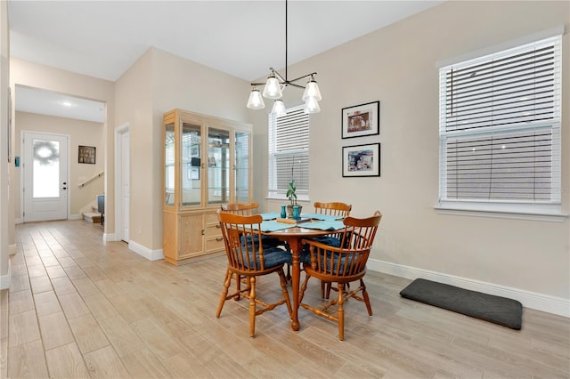 dining space featuring a notable chandelier and light wood-type flooring