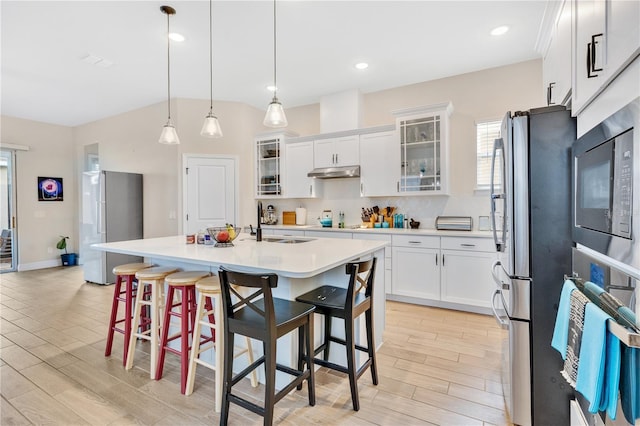 kitchen with white cabinetry, stainless steel fridge, oven, and hanging light fixtures